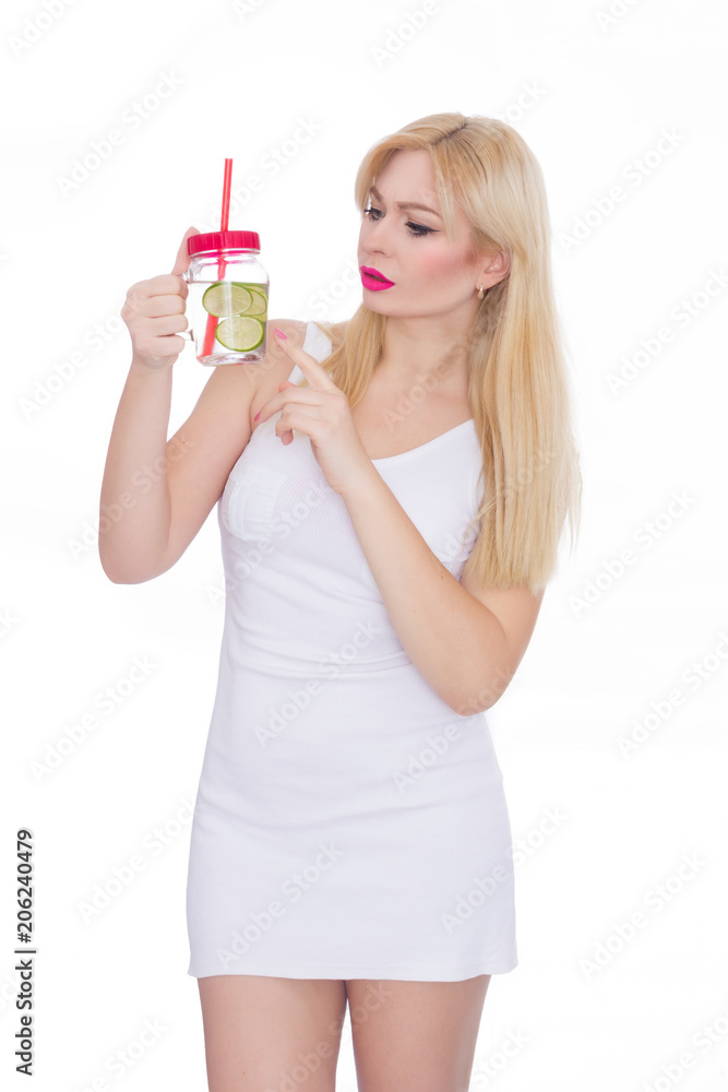 A friendly blond woman holds a glass of water and lime in her hands. A girl is drinking lemonade. Concept - healthy food, thirst quenching in summer
