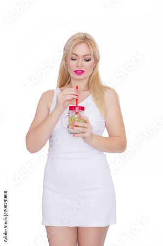 A friendly blond woman holds a glass of water and lime in her hands. A girl is drinking lemonade. Concept - healthy food, thirst quenching in summer