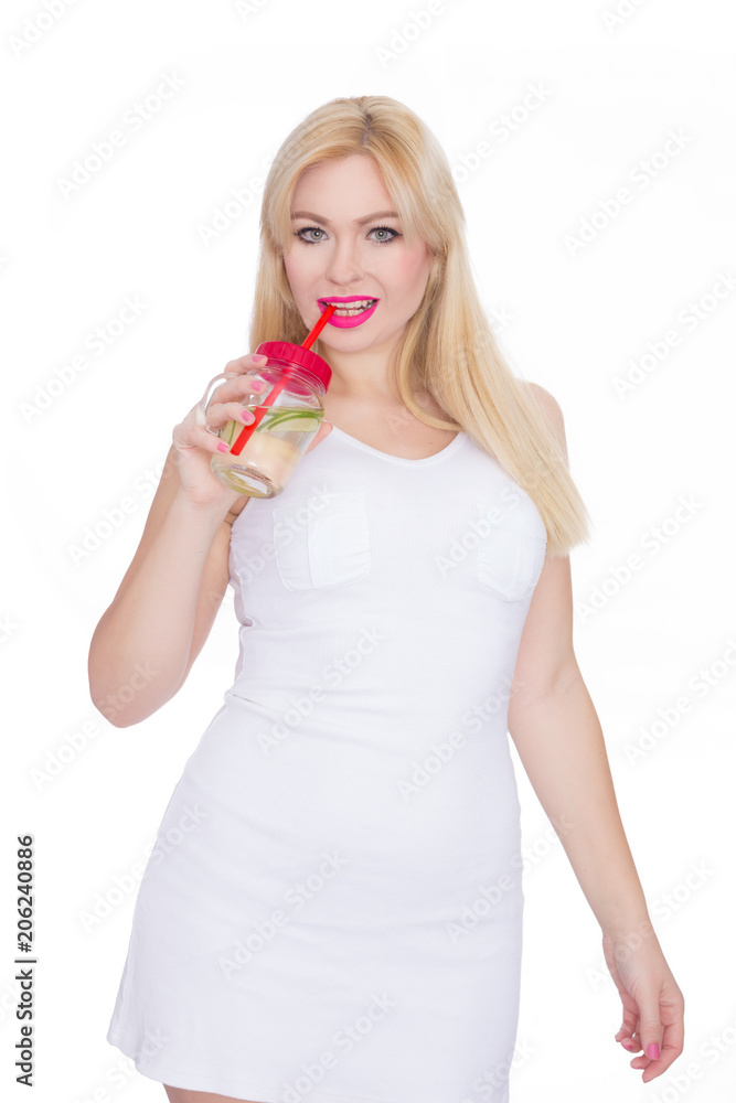 A friendly blond woman holds a glass of water and lime in her hands. A girl is drinking lemonade. Concept - healthy food, thirst quenching in summer A friendly blond woman holds a glass of water and lime in her hands. A girl is drinking lemonade. Concept - healthy food, thirst quenching in summer