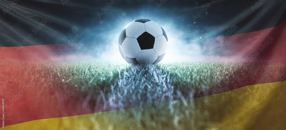 Fototapeta Piłka nożna na trawniku stadionu z flagą Niemiec