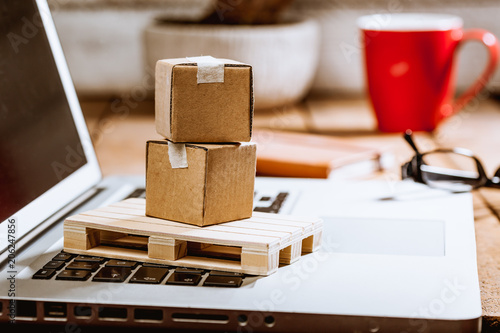 Foto Carton boxes on computer as online shopping logistics concept