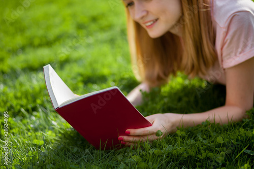 Girl reading a book in the Park. close up