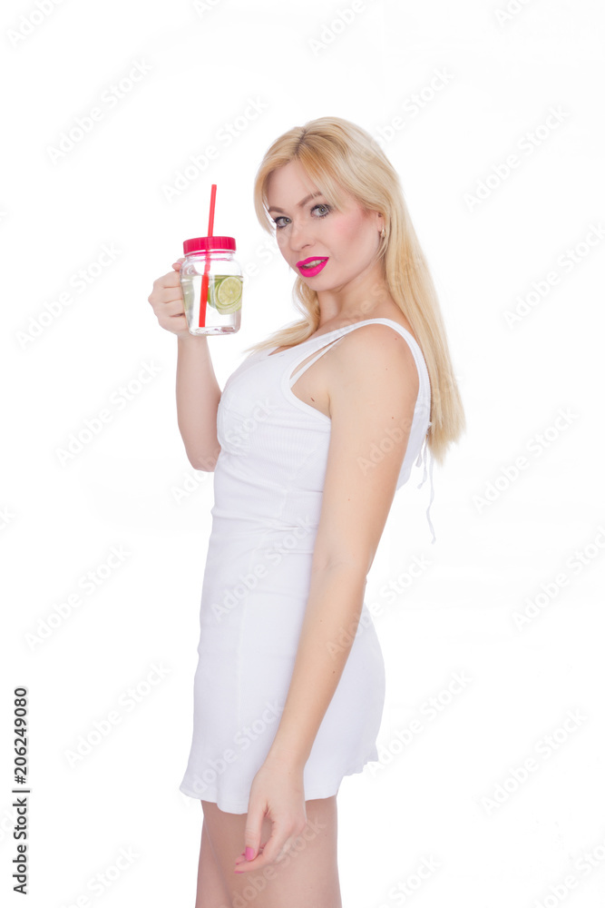 A friendly blond woman holds a glass of water and lime in her hands. A girl is drinking lemonade. Concept - healthy food, thirst quenching in summer A friendly blond woman holds a glass of water and lime in her hands. A girl is drinking lemonade. Concept - healthy food, thirst quenching in summer