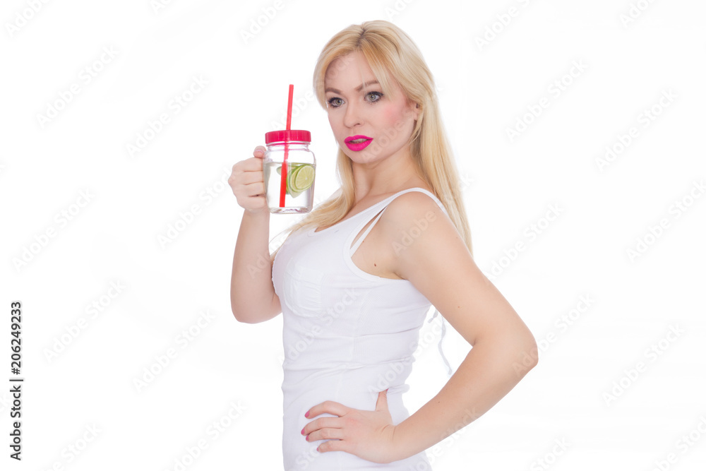 A friendly blond woman holds a glass of water and lime in her hands. A girl is drinking lemonade. Concept - healthy food, thirst quenching in summer A friendly blond woman holds a glass of water and lime in her hands. A girl is drinking lemonade. Concept - healthy food, thirst quenching in summer
