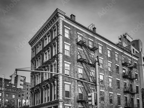 Black and white picture of an old building with fire escapes, New York City, USA.