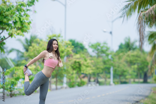 Asian sporty woman stretching body breathing fresh air in the park,Thailand people,Fitness and exercise concept