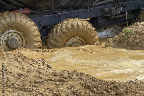 big wheels in the mud. The large wheels of a truck stuck in the mud.