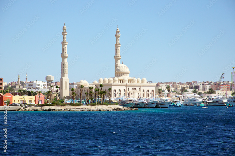 Seascape with ships in the seaport and with a mosque in the background. Hurghada, Egypt