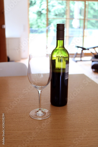 Glas und Weinflasche auf dem Esstisch