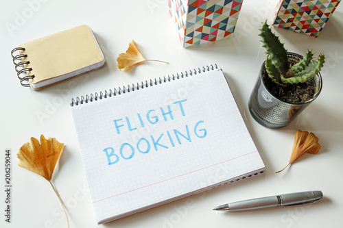 flight booking written in notebook on white table photo