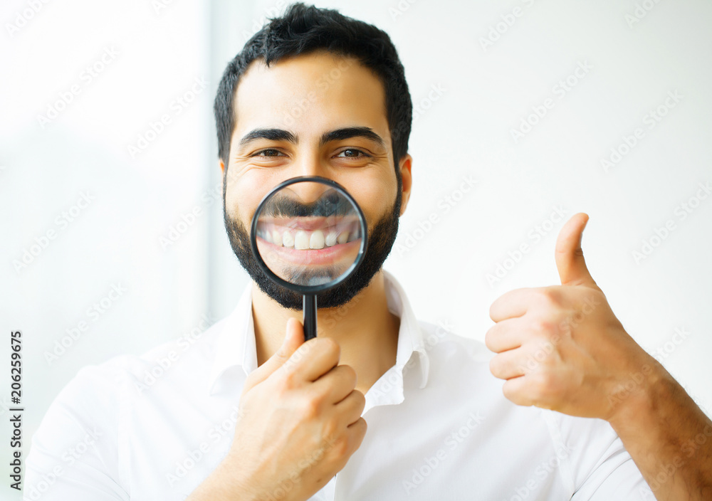 Businessman with magnifying glass zooming on his smile Businessman with magnifying glass zooming on his smile