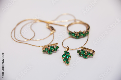 set of gold earrings, ring and pendant with emeralds