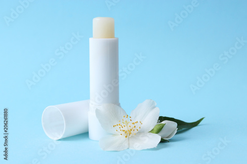 lip balm and flowers on a colored background. minimalism, the top