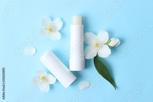 lip balm and flowers on a colored background. minimalism, the top