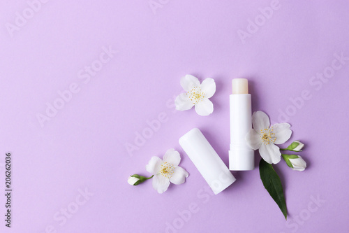 lip balm and flowers on a colored background. minimalism, the top © White bear studio 