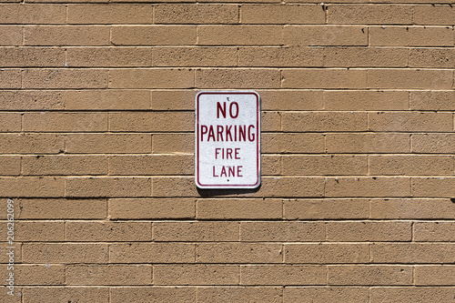 No Parking Fire Lane sign on cinder block wall photo