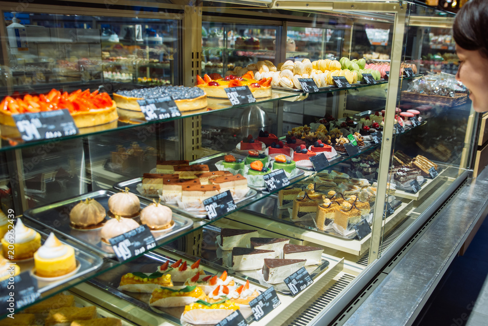 woman choose sweets in store. deserts shop