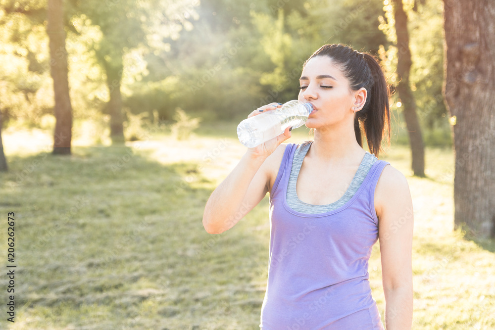 Young woman drinking water after workout, feeling good. Active lifestyle. Young woman drinking water after workout, feeling good. Active lifestyle.