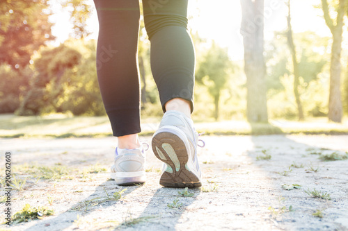 Woman running at sunset in park. Fitness and workout.