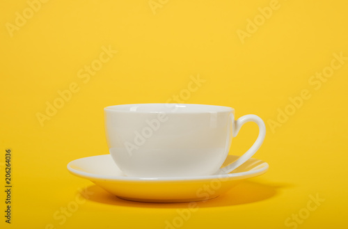 one simple coffee cup on yellow color background, closeup photo