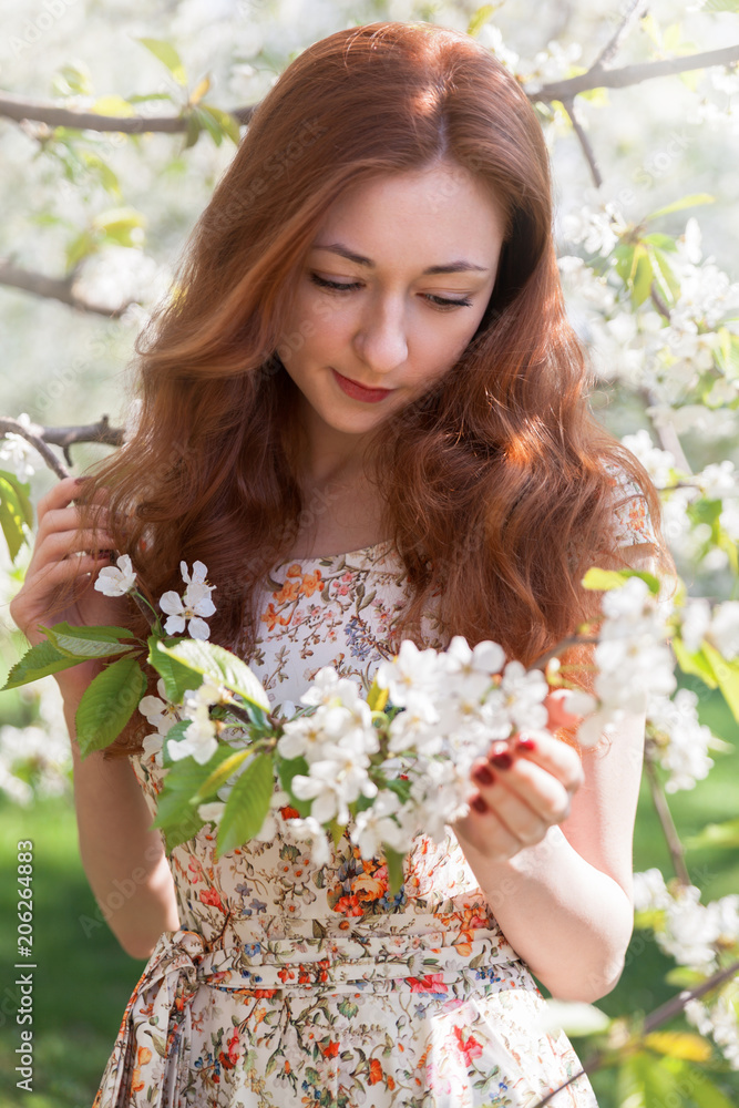 Young ginger hair woman near white tender blossoming tree. fairy dreamlike mood of the spring and summer. Beautiful romantic lady smiling bride, wedding. Copy space background. Young ginger hair woman near white tender blossoming tree. fairy dreamlike mood of the spring and summer. Beautiful romantic lady smiling bride, wedding. Copy space background.