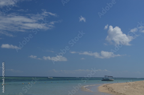 A blue sky over a white beach with turquoise water
