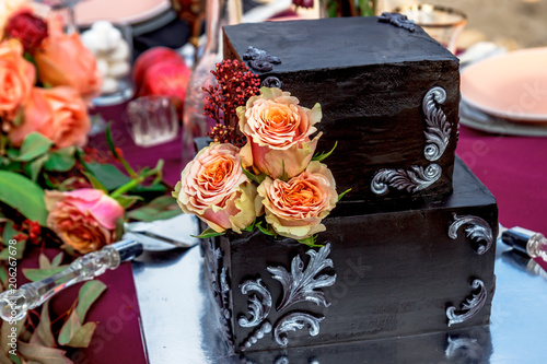 Black wedding cake with natural roses photo
