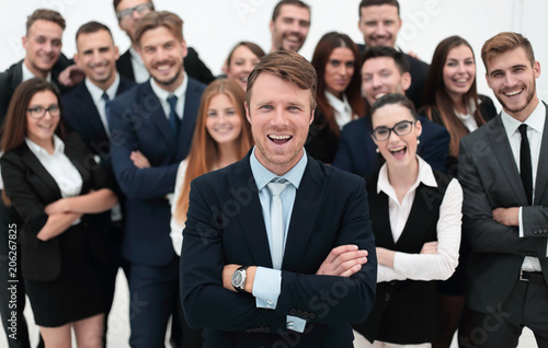 smiling businessman standing on background of her business team.