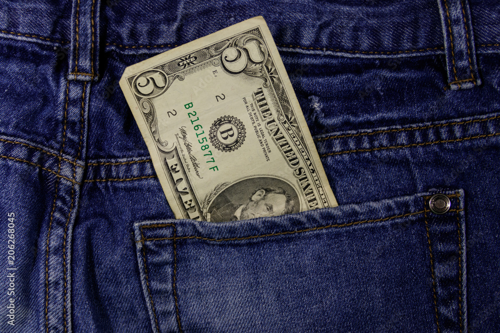 Five dollars banknote in the pocket of blue jeans Five dollars banknote in the pocket of blue jeans