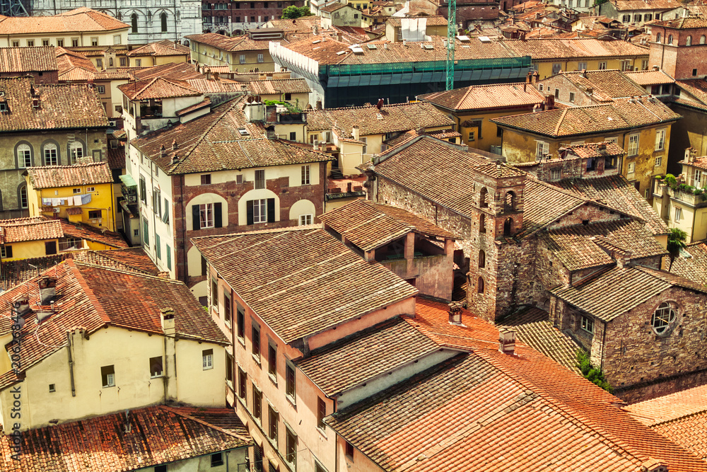 The red rooftops of buildings clustered close together in Lucca, Italy