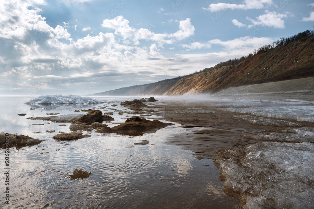 a misty spring morning on the snowy shore of a calm river overlooking the mountains a misty spring morning on the snowy shore of a calm river overlooking the mountains