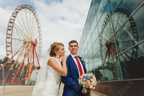 wedding couple of newlyweds in the background of a Ferris wheel in the park