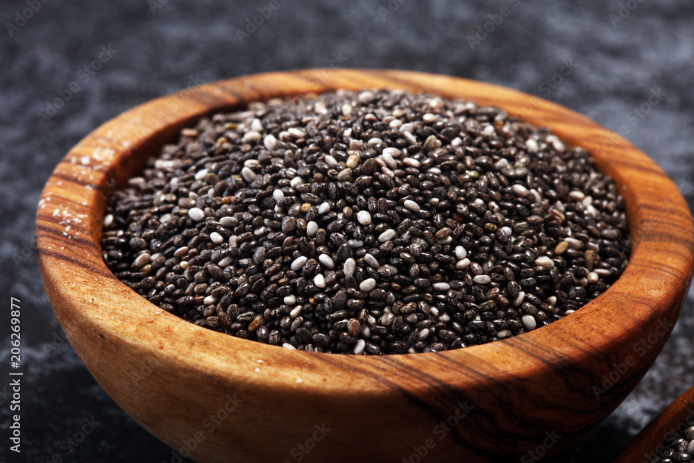 Healthy Chia seeds in a wooden spoon on the table close-up Healthy Chia seeds in a wooden spoon on the table close-up