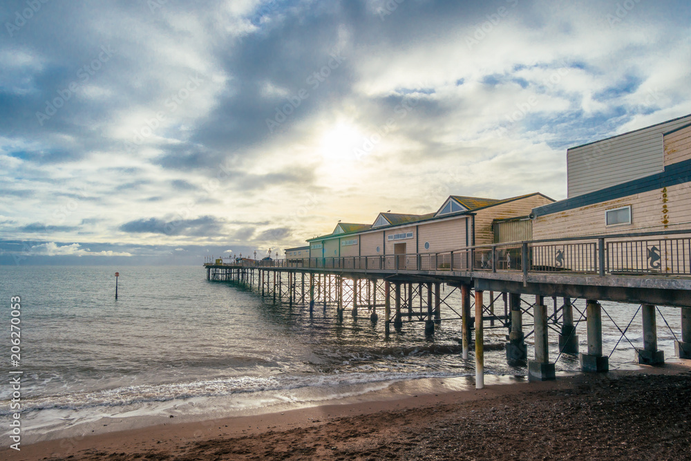 Teignmouth Pier with dramatic clouds and waves.