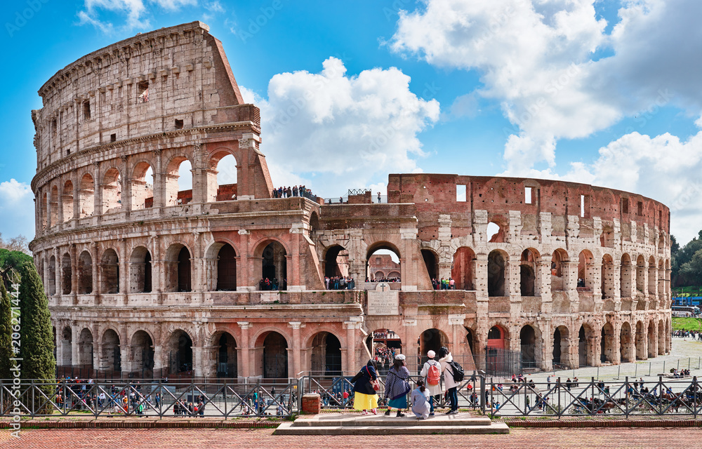 Obraz premium Colosseum seen from the archaeological site square Francesca Romana, tourists admire the Colosseum
