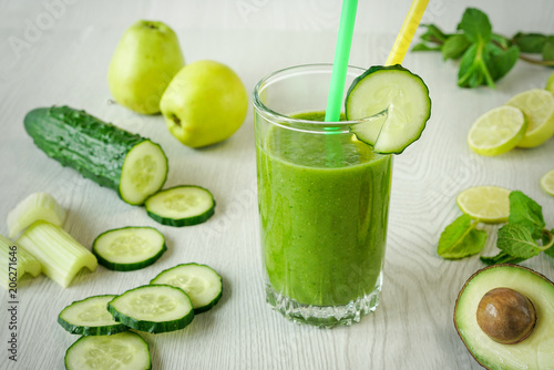 Photography A glass of green vegetable smoothies on a white wooden background