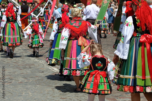 Local people in traditional folk costumes from Lowicz region in Poland walk in Corpus Christi procession