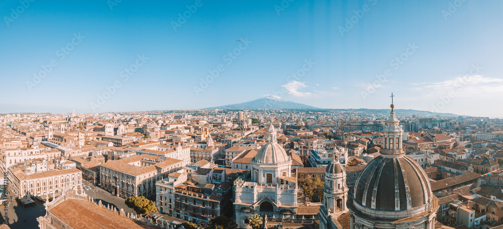 Aerial view of the Cathedral of Sant'Agata in the middle of Catania with Etna volcano on the background - obrazy, fototapety, plakaty 