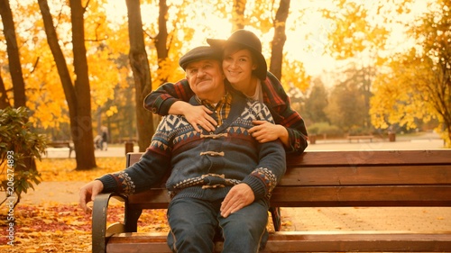 Young woman and her old father on the meeting in the autumn park