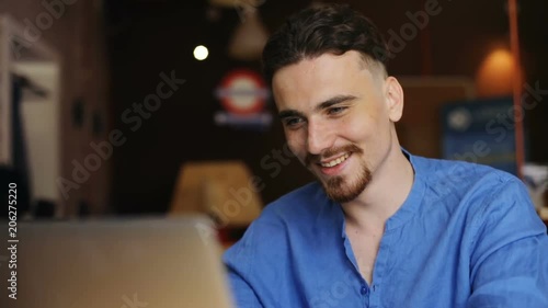 portrait of smiling man thinking about new idea for business startup thoughtful looking away cheerful happy face male programmer web developer designer working on laptop at office comparing website photo