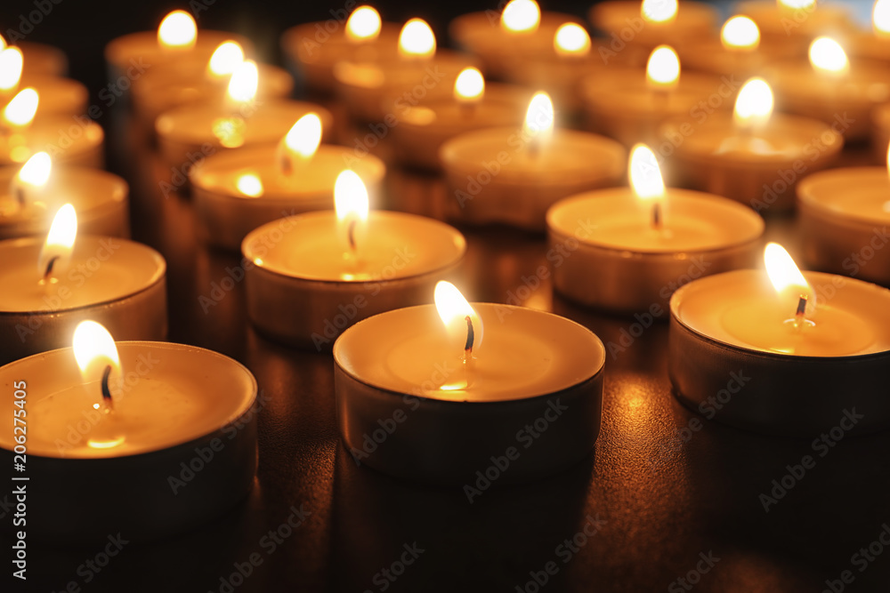Wax candles burning on table in darkness, closeup Wax candles burning on table in darkness, closeup