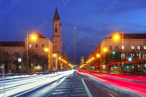 Ludwigstrasse avenue with light tracks and Church St. Louis, called Ludwigskirche, during evening blue hour in Munich, Germany © Kavalenkava