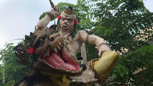 slow motion clip of a rotating ogoh-ogoh effigy and dragon statue on a kuta street bali photo