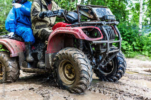 Couple driving off-road with quad bike or ATV