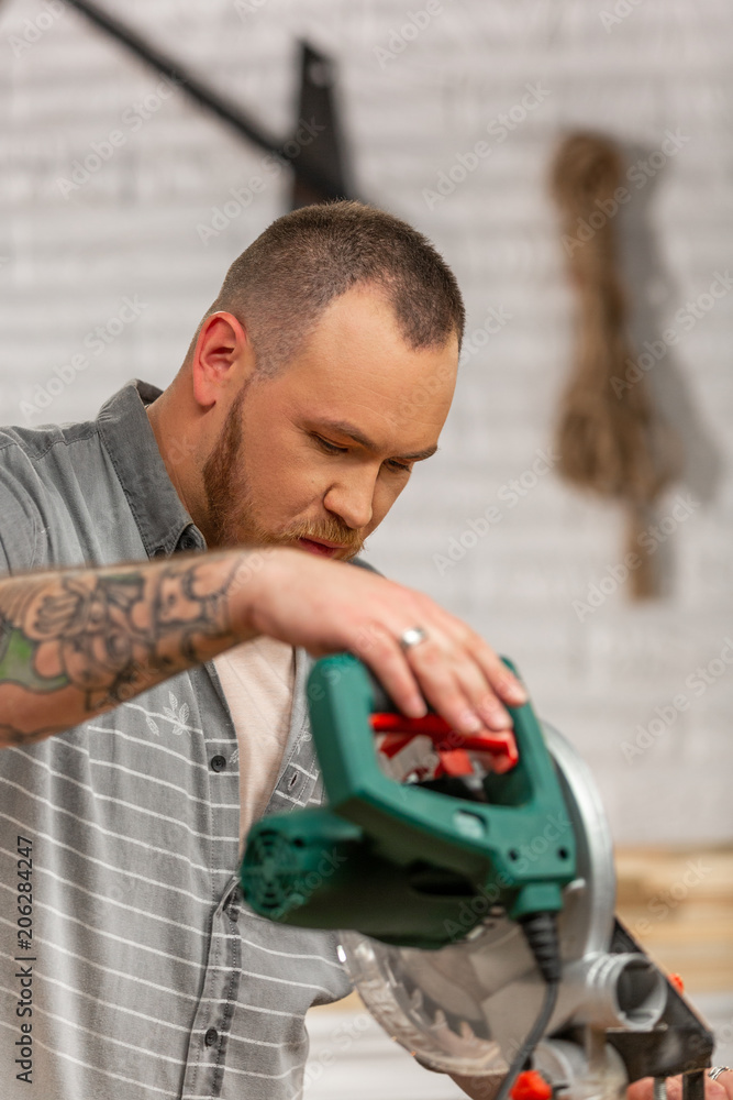 Man sawing wood with a circular saw on a workbench Man sawing wood with a circular saw on a workbench