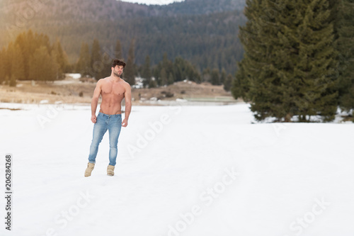 Model Flexing Muscles Outdoors in Nature