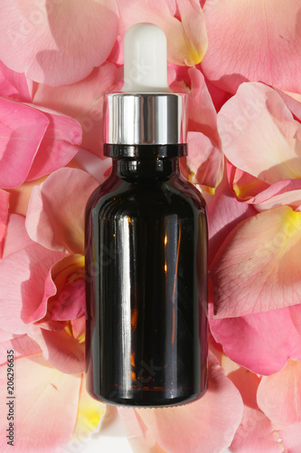 Pure natural essential rose oil .rose oil in a glass brown bottle on rose petals.Natural Organic Vegan Cosmetics