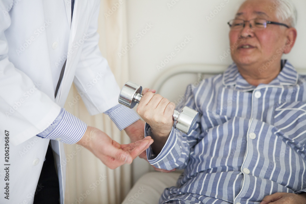 Obraz premium 病院で、リハビリをしている患者と、補助をしている医師。