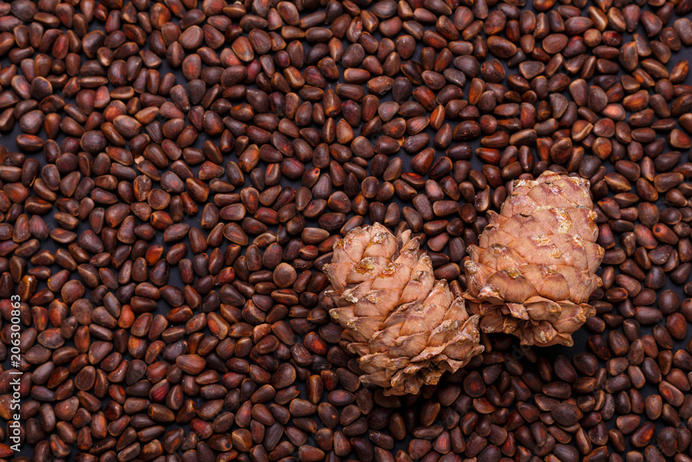Fototapeta premium Pine nuts in shells as a background Two hole cedar cones Copy space Top view