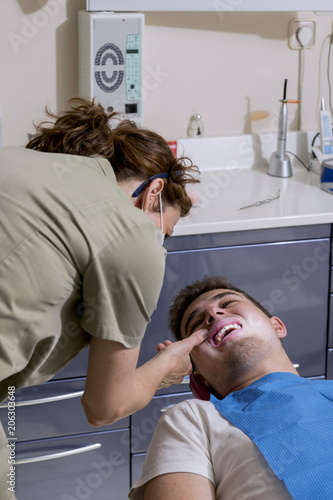 Young man at the dentist, to perform a dental implant